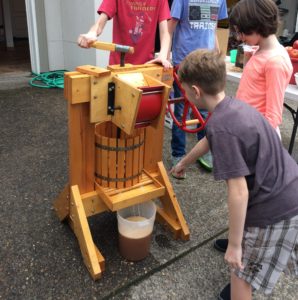 Kids making apple cider