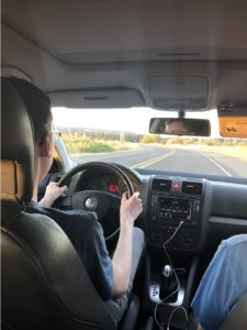 Teen driver in driver's seat as a student driver on a curved road