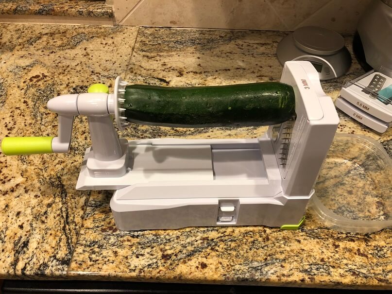 A zucchini loaded in a vegetable spiralizer cutting tool